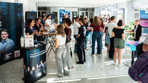Infotag September 2025 Besuchende stehen vor den Infoständen in der Halle.